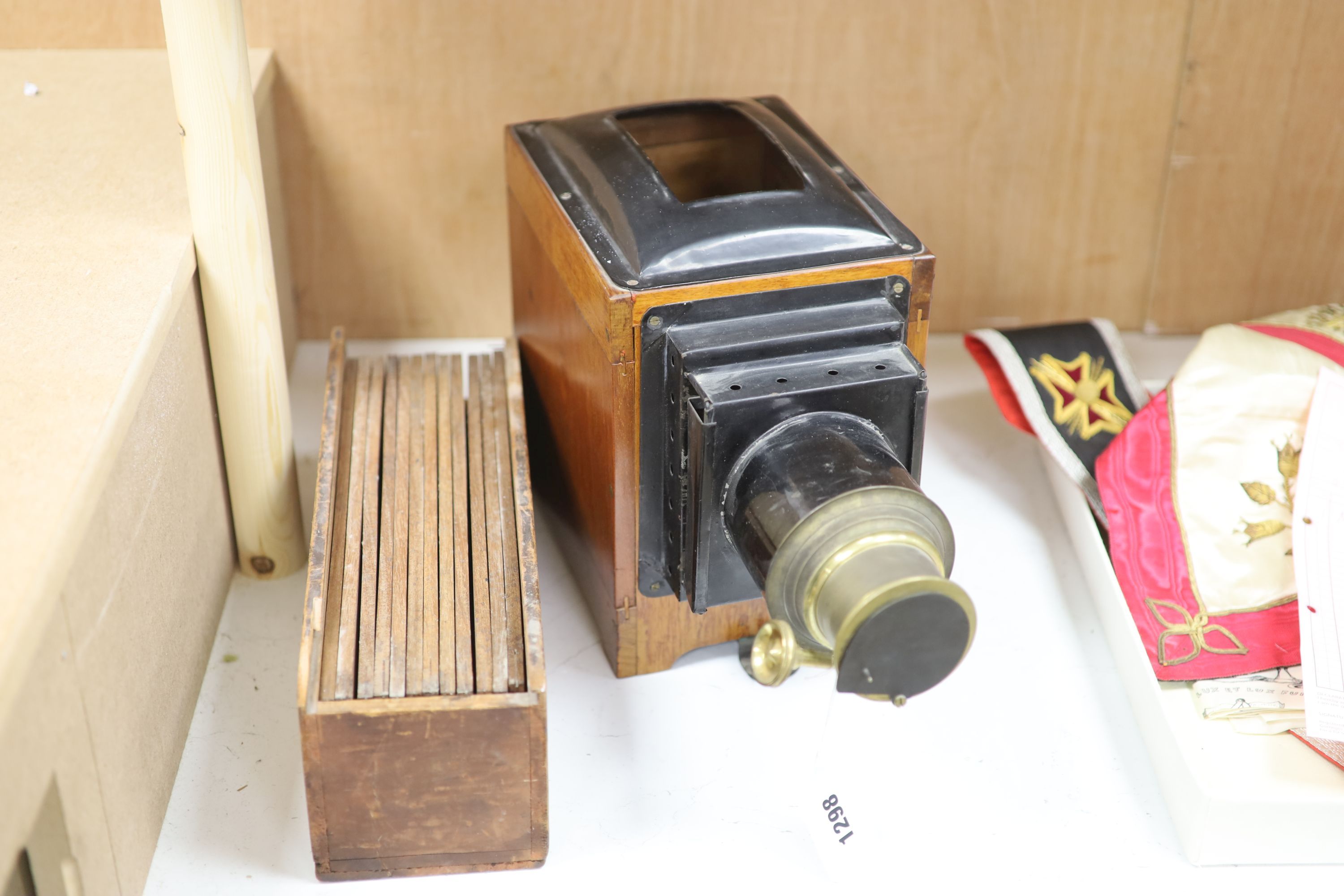 An early 20th century mahogany and brass magic lantern, together with twelve painted glass slides